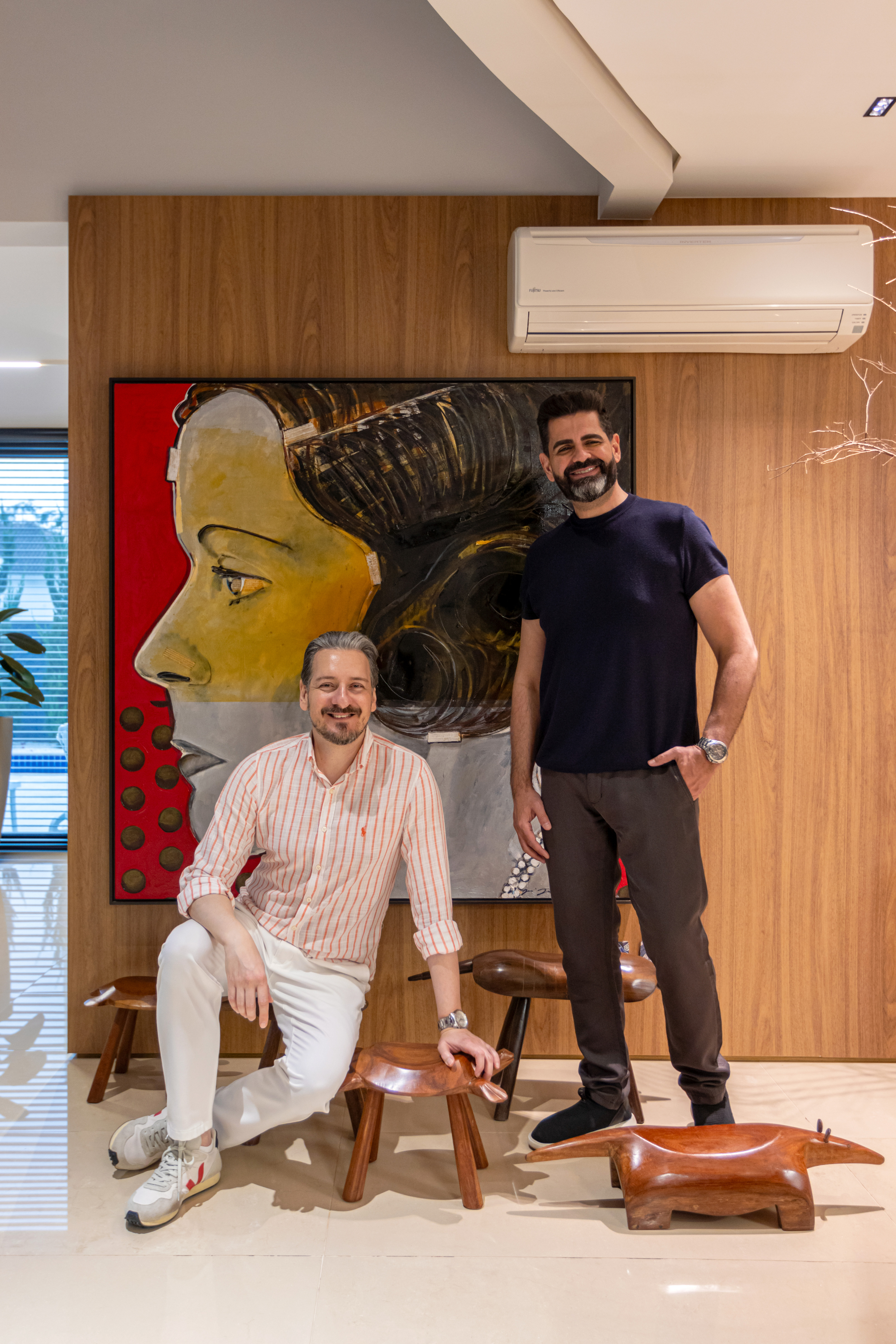 Alessandro and Ricardo, the firm’s founders, standing side by side in a relaxed pose and smiling.